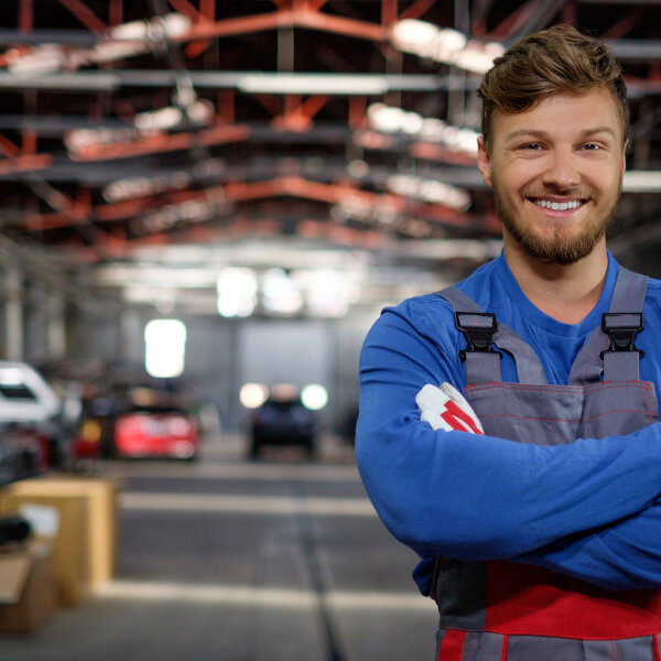 Cheerful serviceman in a car workshop Cheerful serviceman in a car workshop